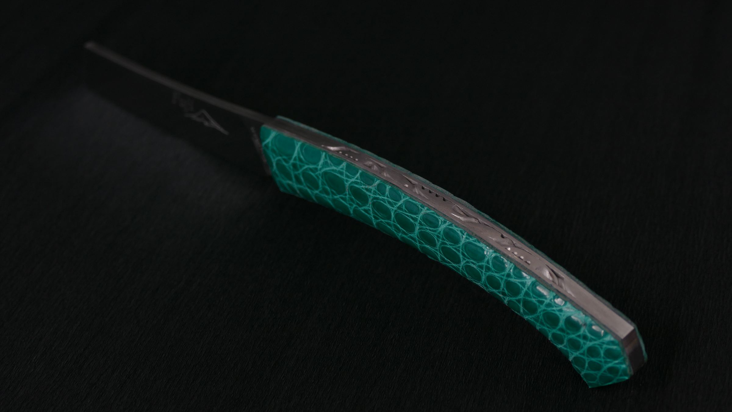 Couteau au manche en cuir de crocodile vert, guillochage sur le dos